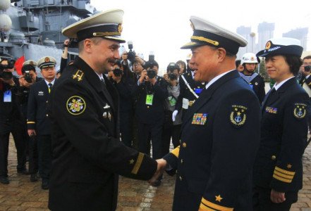 In this photo released by China's Xinhua News Agency, Rear Adm. Du Xiping, front right, deputy commander of China's Beihai Fleet, shakes hands with Captain First Rank Sergei Yuriyevich Zhuga of Russia's Pacific Fleet during a welcome ceremony at a naval base in Qingdao, east China's Shandong Province, Saturday, April 21, 2012. A China-Russia joint maritime drill is scheduled from April 22 to 27 on the Yellow Sea, Xinhua said. (AP Photo/Xinhua, Zha Chunming) NO SALES