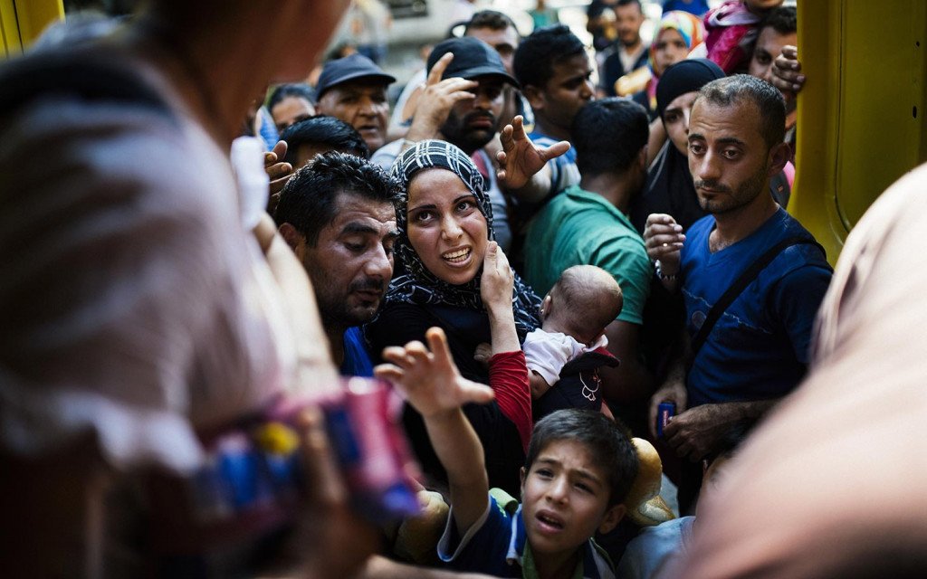 TOPSHOTS Migrants wait to receive food distributed by Macedonian volunteers at the train station in Gevgelija on the Macedonian-Greek border on August 4, 2015. Many migrants try to cross Macedonia and Serbia to enter the European Union via Hungary, a country that will finish building its anti-migrant fence on its southern border with Serbia by August 31, ahead of a previous November deadline. AFP PHOTO / DIMITAR DILKOFFDIMITAR DILKOFF/AFP/Getty Images