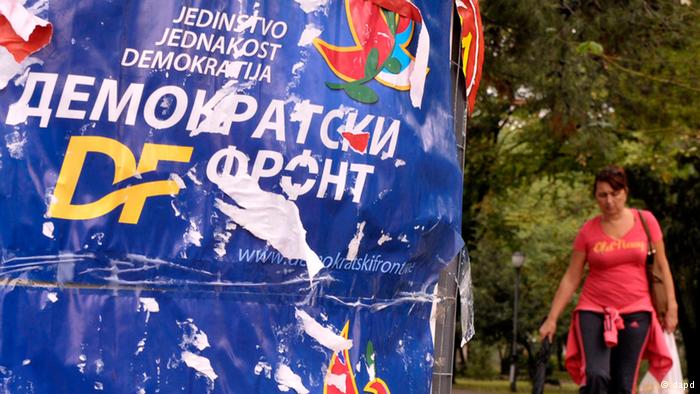 A woman passes by main opposition Democratic Front election poster reading Unity, Equality, Democracy