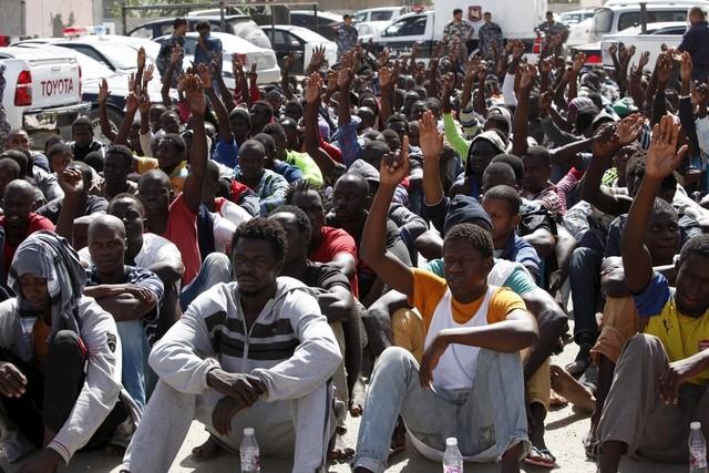 Illegal migrants sit at a temporary detention centre after they were detained by Libyan authorities in Tripoli, Libya October 8, 2015 . Photo: REUTERS/Ismail Zitouny