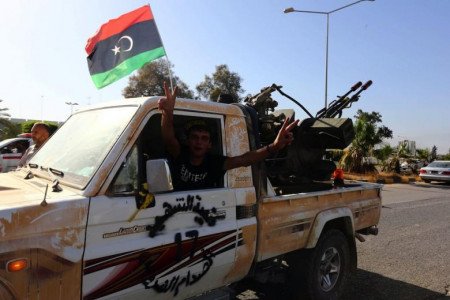 An Islamist fighter from the Fajr Libya (Libyan Dawn) coalition flashes the V sign for victory at the entrance of Tripoli international airport on August 24, 2014, after capturing it from Zintan force, allies of rogue general Khalifa Haftar, following many days of clashes. (Photo: AFP-Mohammed Turkia)