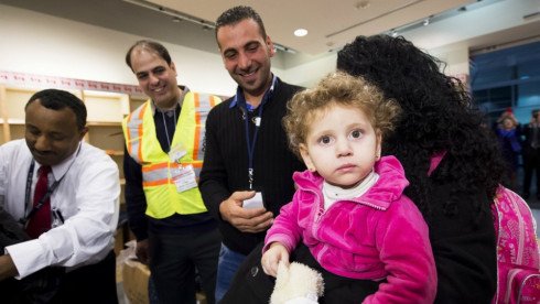 Sixteen-month-old Madeleine Jamkossian, right, arrives with her family, refugees fleeing the Syrian civil war, at Pearson International airport, in Toronto, on Friday, Dec. 11, 2015. (Nathan Denette / THE CANADIAN PRESS)