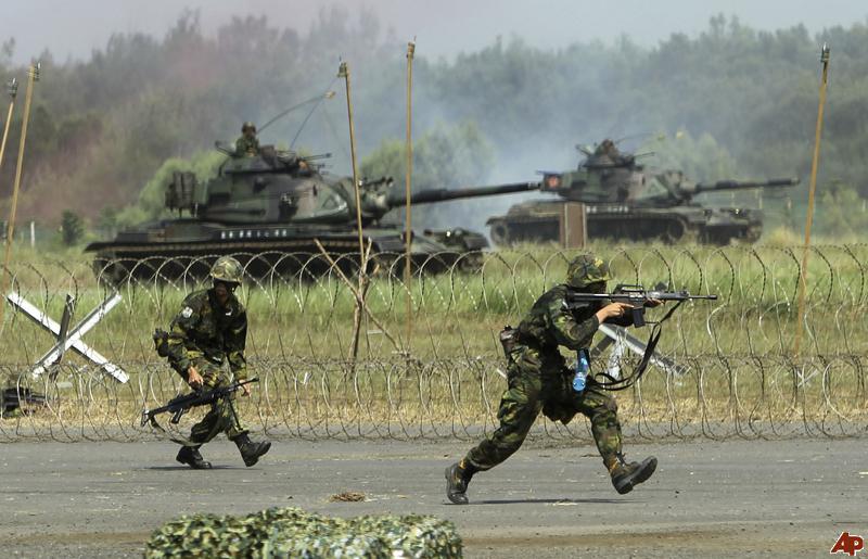 Soldiers of the Taiwan army armored tank division advance with M-60 tanks