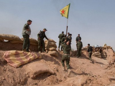A Kurdish People’s Protection Units (YPG) flag is raised in a village near Mount Abdulaziz on Thursday, after retaking the territory from Isis. Reuters