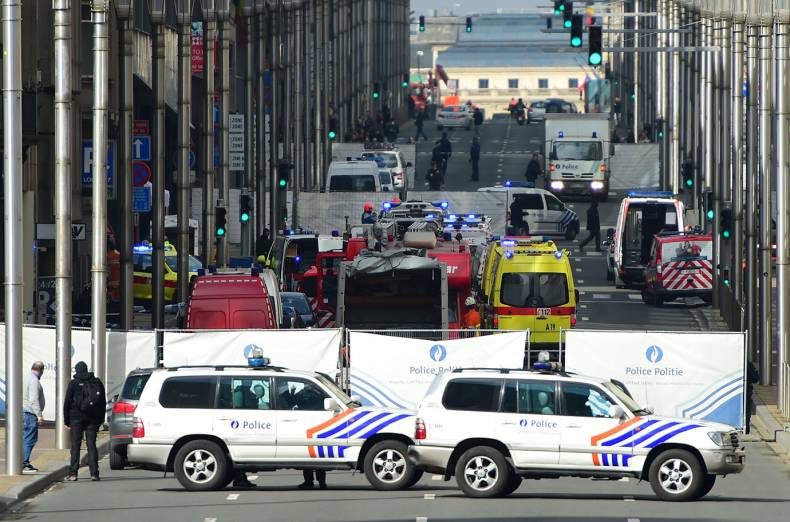 Policemen stand guard at the entrance of a security perimeter set near Maalbeek metro station, in Brussels, after a blast at this station near the EU institutions caused deaths and injuries.
