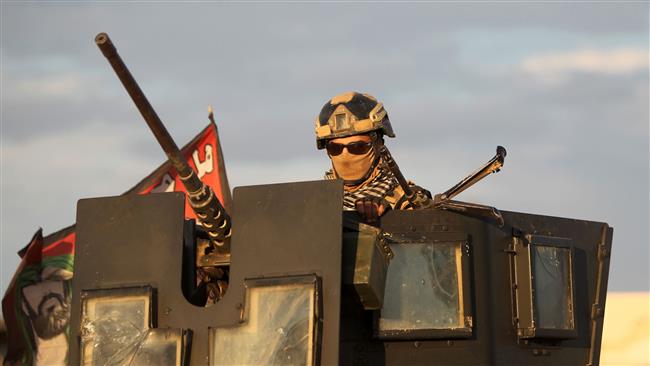 A soldier stands behind a shield atop an armored vehicle as Iraqi army troops drive on February 2, 2016 towards al-Sjarih area, east of the city of Ramadi, the capital of Iraq's Anbar Province. (AFP photo)
