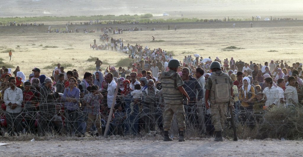 635903150877606825348982091_turkish-soldiers-stand-guard-syrian-refugees-wait-behind-border-fences