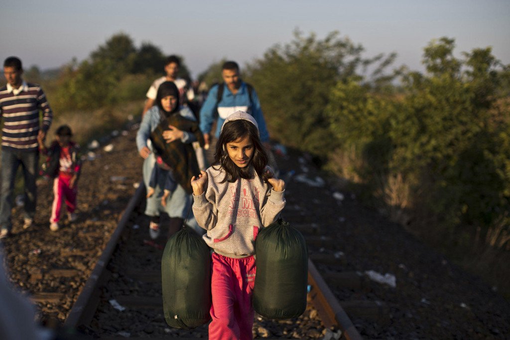 Syrian refugees make their way on a railway track after crossing the border between Serbia and Hungary in Roszke, southern Hungary, Monday, Sept. 14, 2015. (AP Photo/Muhammed Muheisen)