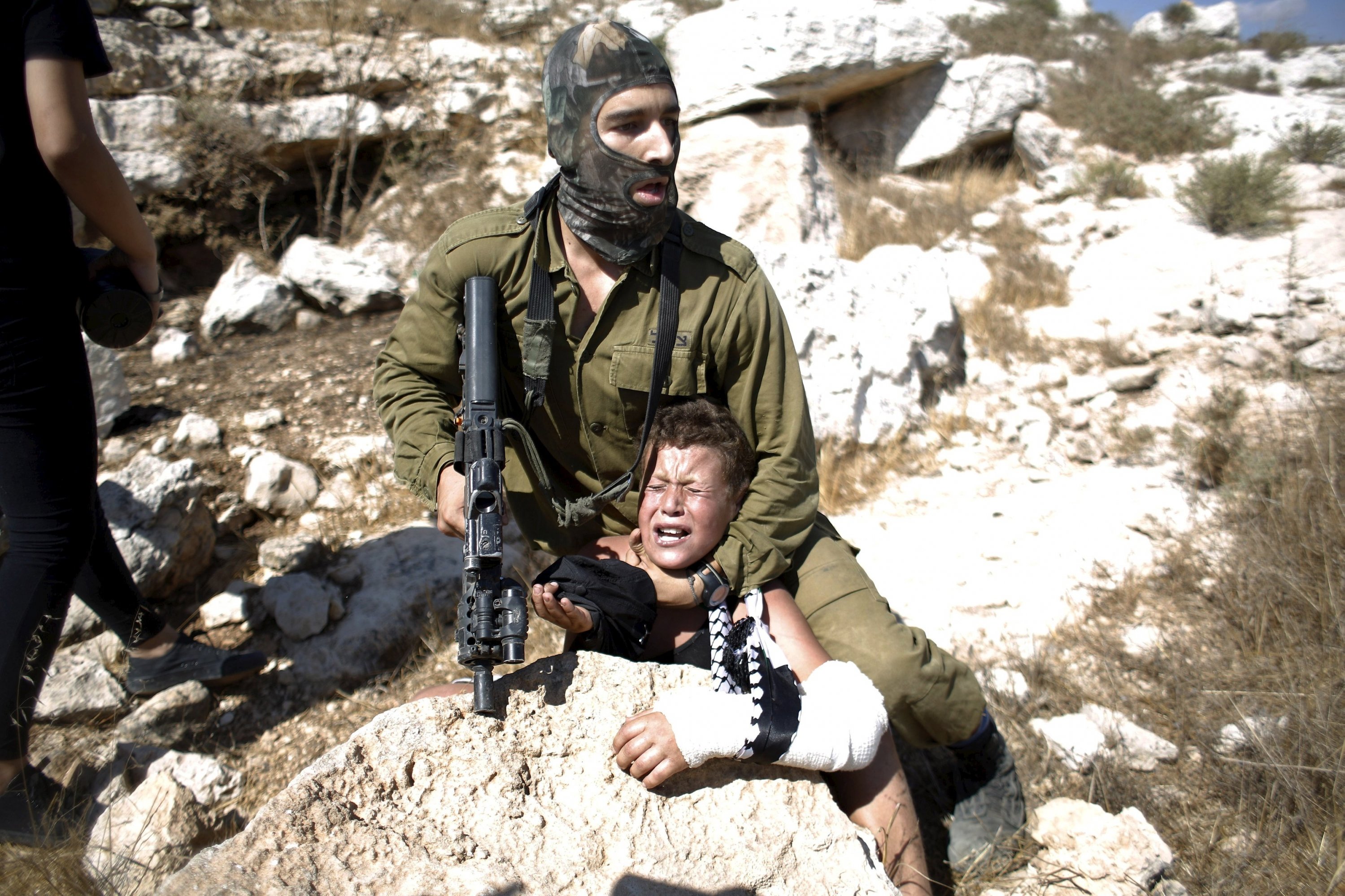 An Israeli officer captures a kid during demonstration in Ramallah