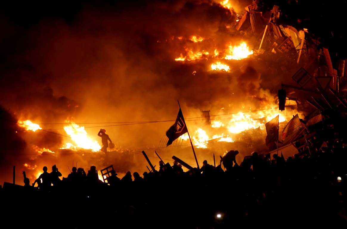 Anti-government protesters stand behind burning barricades in Kiev's Independence Square February 19, 2014. Ukrainian President Viktor Yanukovich accused pro-European opposition leaders on Wednesday of trying to seize power by force after at least 26 people died in the worst violence since the former Soviet republic gained independence.  REUTERS/Vasily Fedosenko (UKRAINE - Tags: POLITICS CIVIL UNREST)