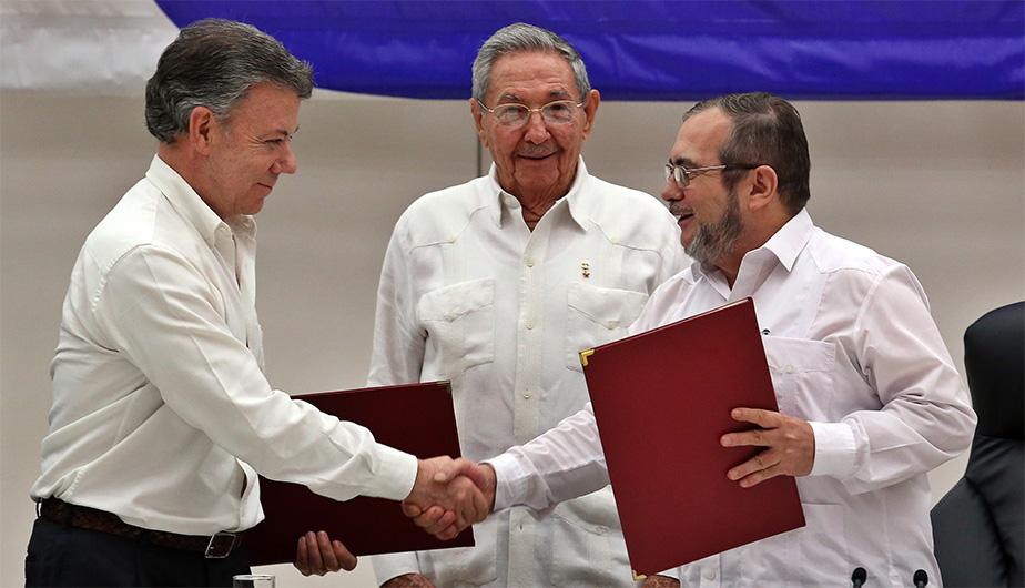 Juan Manuel Santos, Timoleón Jiménez after signing the peace agreement, Raúl Castro in the back