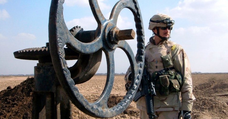 A U.S. soldier stands next to an oil pipeline valve in Iraq in 2005. (Photo: YourLocalDave/cc/flickr)