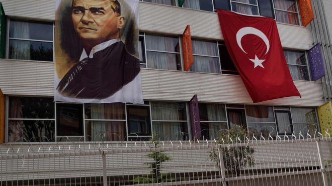 A portrait of Mustafa Kemal Ataturk hangs next to a Turkish flag on the outside of a religious school in IstanbulI. AFP