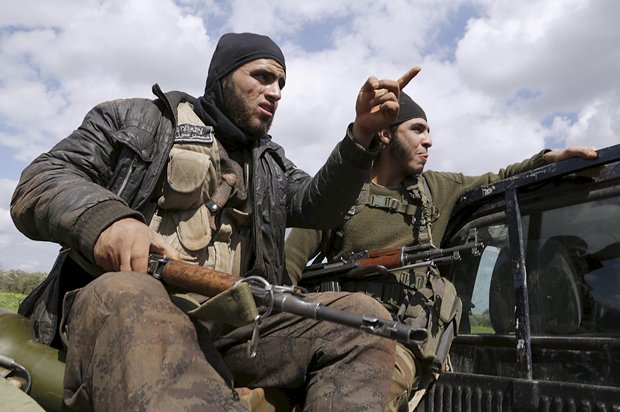 Islamic Ahrar al-Sham fighters gesture as they ride a pickup on the frontline of Idlib city in northern Syria, where they announced a battle to liberate the city from forces loyal to Syria's president Bashar Al-Assad March 20, 2015. REUTERS/Khalil Ashawi  - RTR4U8W9