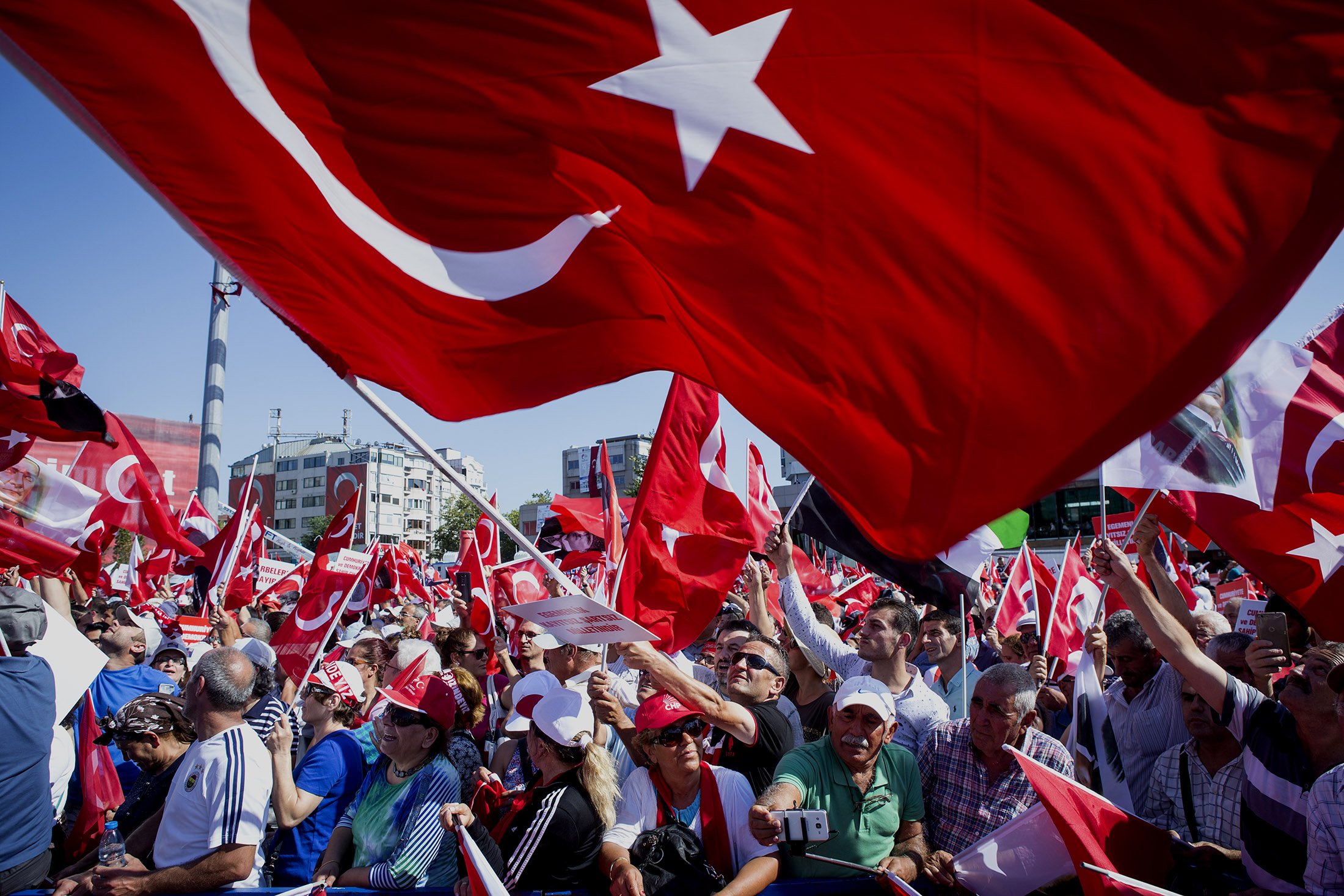 Political supporters wave Turkish national flags during a pro democracy demonstration in Istanbul, Turkey, on Sunday, July 24, 2016. Turkey's government is setting up an inner cabinet to oversee the implementation of the state of emergency it declared after the botched coup, ramping up the effort to purge the influence of its accused mastermind. Photographer: Kerem Uzel/Bloomberg