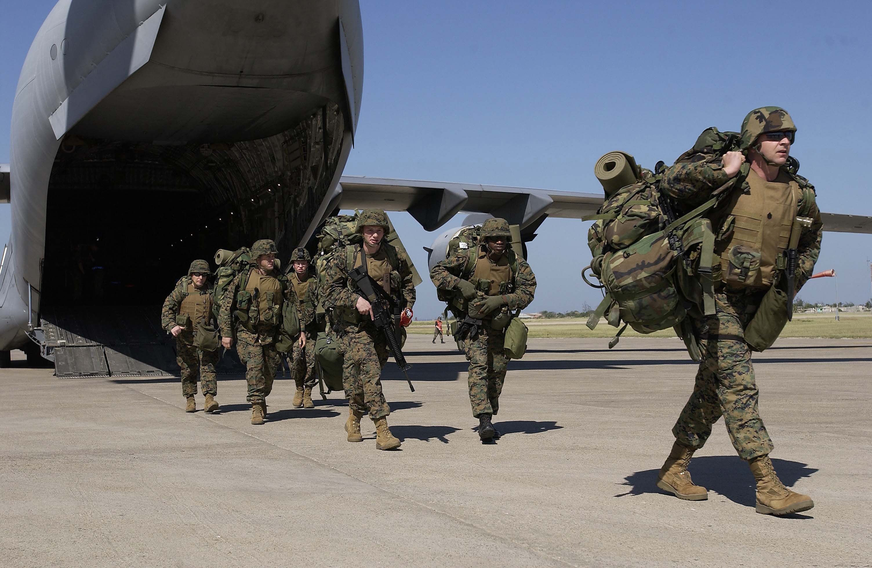 040304-F-2828D-065 U. S. Marines exit a C-17 Globemaster III at the Port-au-Prince airport in Haiti on March 3, 2004. U.S. troops are deploying to Haiti at the request of the new President of Haiti to help promote the constitutional political process, to create conditions for the arrival of the U.N. multinational force, facilitate humanitarian assistance and secure key sites in the Haitian capital Port-au-Prince. DoD photo by Tech. Sgt. Andy Dunaway, U.S. Air Force. (Released)