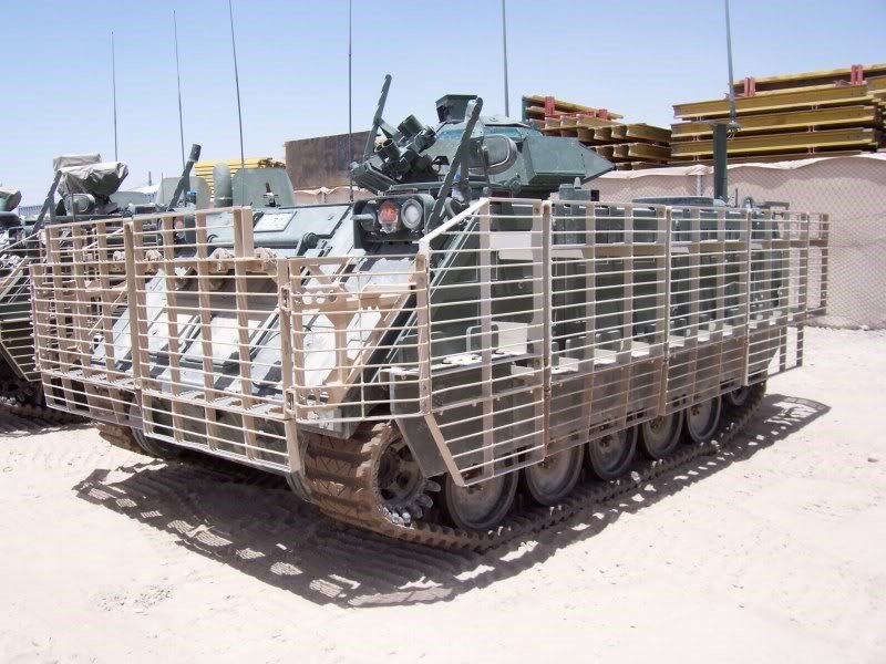 M113A3 fitted with slat armor to protect against shaped-charge munitions in urban environments. The armor serves the double purpose of allowing for added external stowage of gear.