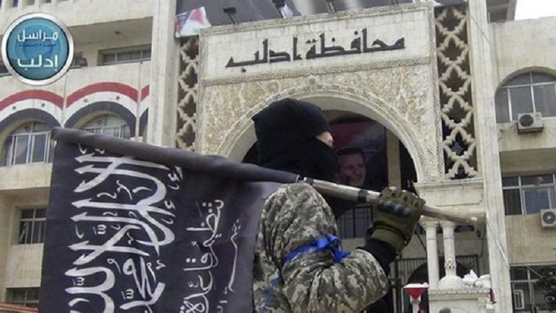 Member of Jabhat Fath al-Sham holds his group flag in Idlib