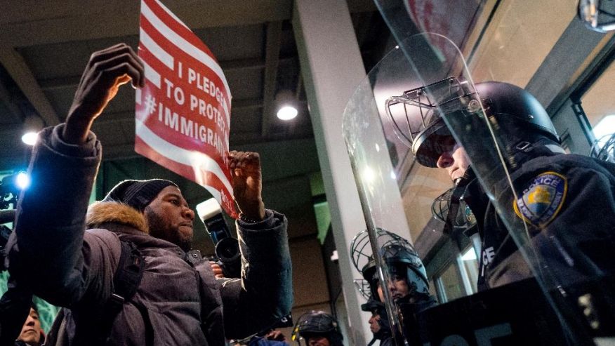 A protester stands facing police officers at an entrance of Terminal 4 at John F. Kennedy International Airport in New York, Saturday, Jan. 28, 2017, after earlier in the day two Iraqi refugees were detained while trying to enter the country. On Friday, Jan. 27, President Donald Trump signed an executive order suspending all immigration from countries with terrorism concerns for 90 days. Countries included in the ban are Iraq, Syria, Iran, Sudan, Libya, Somalia and Yemen, which are all Muslim-majority nations. (AP Photo/Craig Ruttle) (The Associated Press)