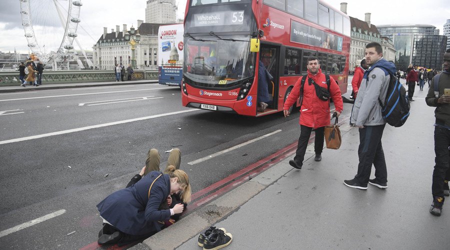 A woman assists an injured person after an incident on Westminster Bridge in London, March 22, 2017. © Toby Melville
